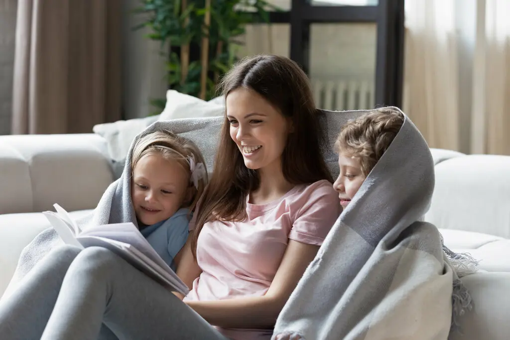 Mutter ließt mit Sohn und Tochter