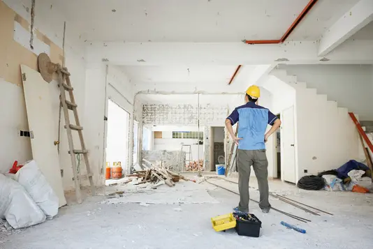 Handwerker betrachtet den Rohbau von innen.